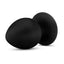 A black silicone butt plug lays flat and showcases its suction cup mount.