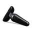 A medium size black PVC anal plug lays flat and showcases its suction cup base.