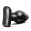 A black PVC butt plug lays flat and showcases its the suction cup base.