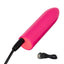 A classic pink bullet vibrator lays flat with its charging cord attached to its base.