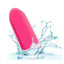 A classic pink bullet vibrator is shown splashing in water to showcase its waterproof properties.