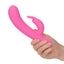 A hand model holds a pink turbo rabbit vibrator to showcase its size.