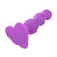 A purple vibrating triple beaded anal probe lays flat and showcases its one power button on the heart shaped stopper base.