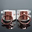 A pair of white faux leather cuffs with interlocking rose gold O-rings. 