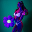 A model wears a UV reactive daisy print mesh bra and panty under a black light to showcase its glow-in-the dark design. 