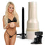 A Fleshlight Girls Elsa Jean star stands holding a textured vaginal masturbator next to its warming stand, iridescent hard shell case and shower mount. 