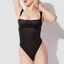 A model wears a sheer black mesh bra bodysuit with thiick satin-sheen elastic shoulder straps.