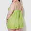 A plus size model wears a sheer green chiffon babydoll with a flyaway split open back. 