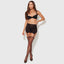 A model wears a sheer black satin bra, panty and garter skirt with satin elastic panty sides.