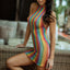 A model wears a crochet halter dress with thong with a vertical rainbow stripe design.