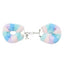 A pair of fluffy faux fur handcuffs with keys lays on a white backdrop in a pastel blue and purple print.