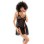 A model wears a sheer black net babydoll dress and panty with side slits from hem to bust. 