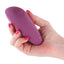 A hand model holds a magenta compact silicone vibrator showcasing its single power button.