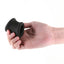 A hand model holds a black silicone ball stretcher showcasing its scale. 