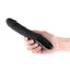 A hand model holds a black phallic vibrator with a veiny shaft and digital display on the base handle.