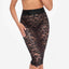 A model wears a black lace midi skirt with a transparent floral lace pattern. 