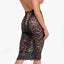 Back view of a model wearing a black lace floral midi skirt with corset-styling lacing down the middle back. 