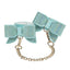 A pair of iridescent aqua holographic faux leather wrist cuffs with bowtie detail studded with diamantés. 