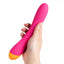 A hand model holds a pink and orange g-spot vibrator showcasing its scale.