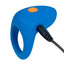 A silicone blue cock ring stands against a white backdrop showcasing its charging cord attached to the side.