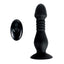 A black silicone thrusting vibrating butt plug lays on a white backdrop next to its remote control. 