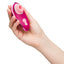 A hand model holds an Iggy Azalea metallic pink clitoral stimulator and showcases its compact size. 