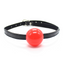 A red rubber ball gag with a thin faux leather strap and buckle sits against a white background.