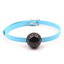 A blue rubber ball gag with a thin faux leather strap and buckle sits against a white background.