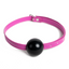 A pink rubber ball gag with a thin faux leather strap and buckle sits against a white background.