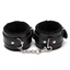 A pair of black faux fur leather wrist cuffs with a silver metal chain and dual snap hooks.
