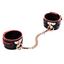A pair of red and black petite faux leather ankle cuffs with a gold t-plate bolted through the front of each cuff.
