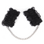 A pair of black scalloped lace wrist cuffs with silver chain lays against a white backdrop. 