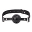 A black faux leather breathable ball gag with a rear adjustable buckle sits against a white backdrop. 